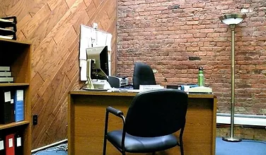 Office with exposed brick and diagonal wood paneling walls