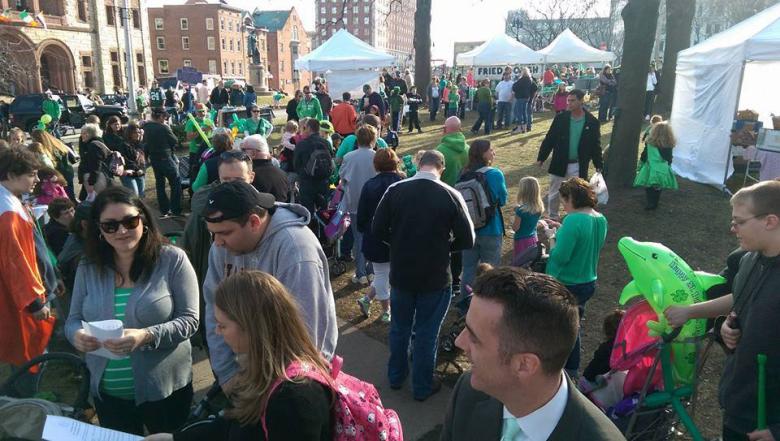 Crowd of people wearing various shades of green celebrating saint patricks day outside