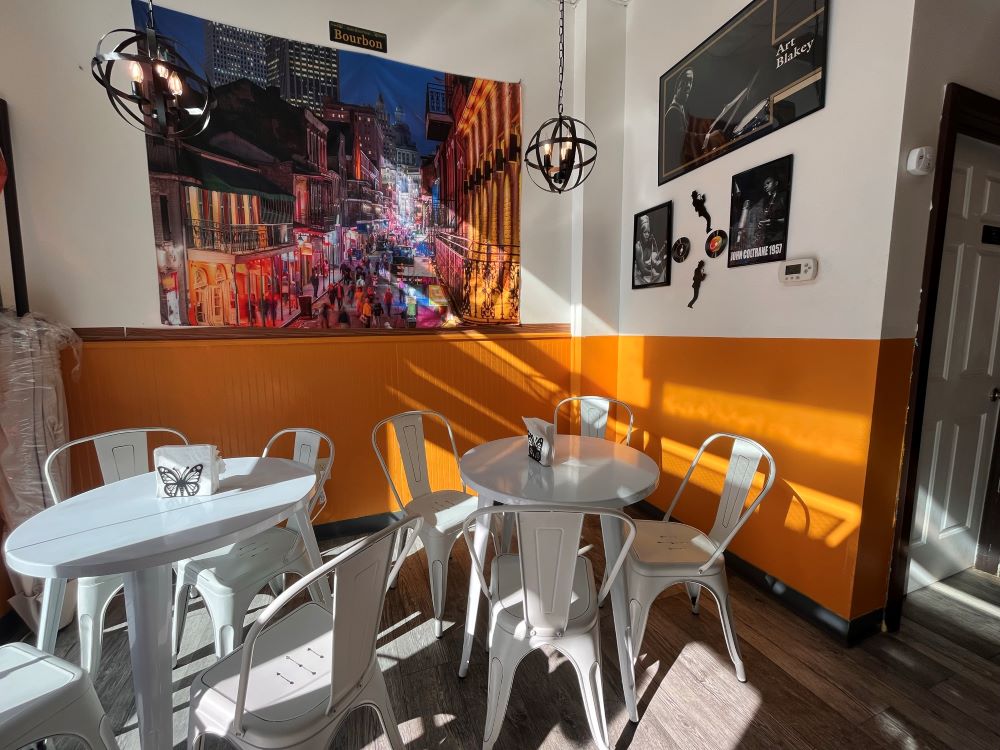 Photo of Beignet Bellies, yellow walls and white tables