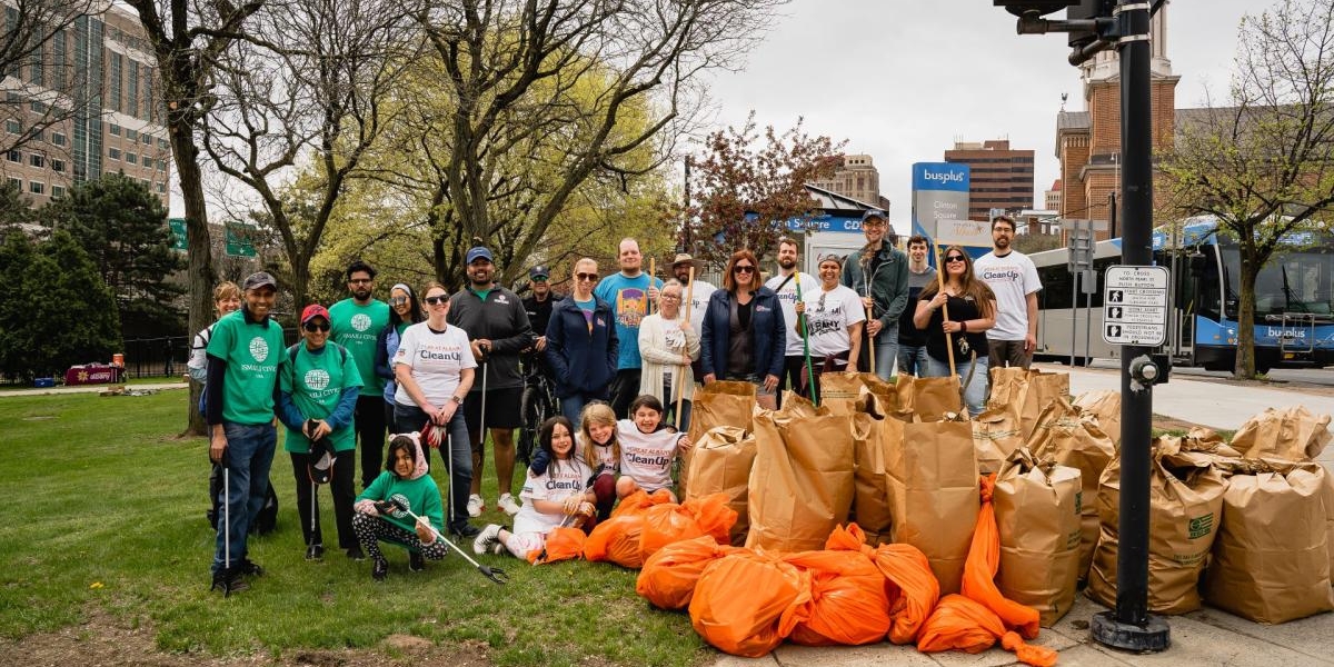 Photo of a group of people at Earth Day CleanUp surrounded by bags of debris, etc.