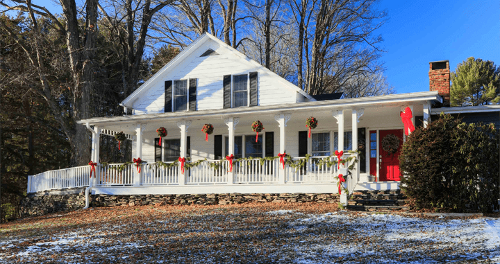 Large white house decorated with red Christmas bows