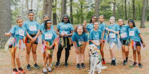 Girls stand in line with matching shirts and running numbers