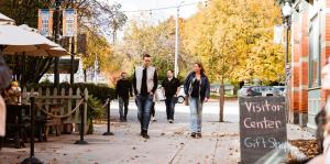 People walking in Quackenbush Square with fall foliage trees 