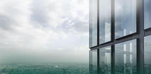 Side of glass building with green haze over skyline