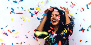 Woman standing in middle of downpouring confetti