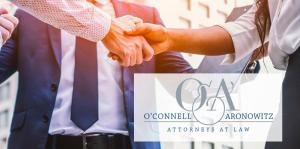 Photo of a business handshake with O'Connell & Aronowitz logo overlaid on it