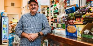 man leaning on store countertop