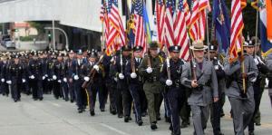 Police officers in uniform marching in procession with flags