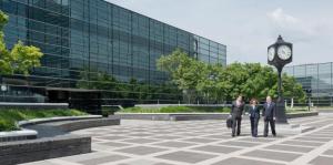 Three lawyers walking in courtyard between glass buildings