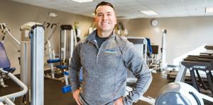 interior view with exercise equipment with a man with a smile