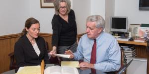 Lawyers with law books and legal papers in office