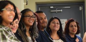 Closeup of people with linked arms smiling