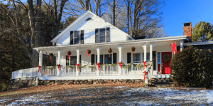 Large white house decorated with red Christmas bows