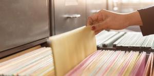 Female hand pulling hanging file out of drawer