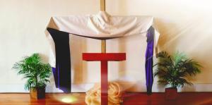 Pulpit with plants, cross, and draped garment