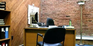 Office with exposed brick and diagonal wood paneling walls