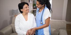 Patient and nurse in front of couch in home