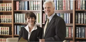 Woman and man in front of bookshelf full of law books