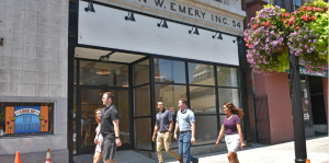 Five pedestrians walk in front of a vacant building that is set to be the new location for Steuben Street Market