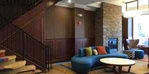 Interior view of the Fairfield Inn and Suites lobby, a coffee table and lounge chairs are in focus. 