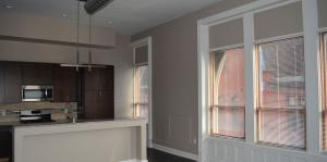 Interior view of a Steuben Place apartment, showing the high ceilings, windows, and kitchen space. 