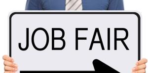 Stock photo of a man holding a sign meant to look like a street sign that is all white with a large black arrow pointing to the right and text that reads "Job Fair" 