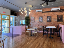 Image of Viva Empanada, Wood floors and pink walls with artwork