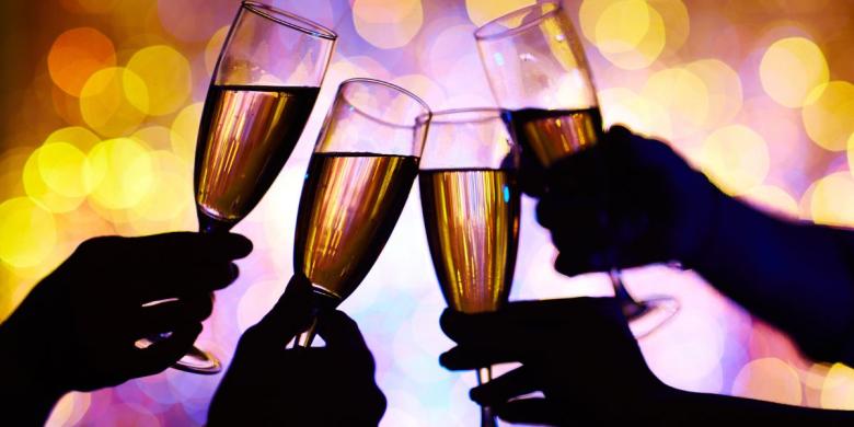 Four silhouetted hands hold champagne flutes in a toast