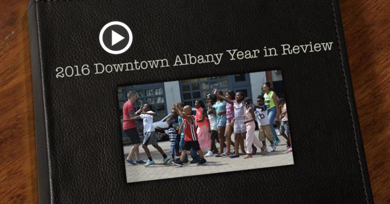 Screenshot of the year in review video superimposed on a leather bound book cover, text above it reads "2016 Downtown Albany Year in Review"