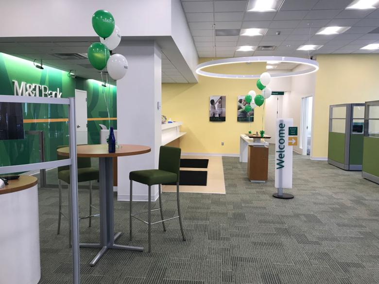 Interior of a newly renovated bank lobby, green balloons celebrate the occasion.